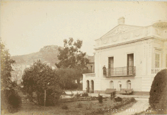 Photographie ancienne d'une villa avec façades moulurées, fronton triangulaire, balcon avec Claire Salles-Eiffel et parc.