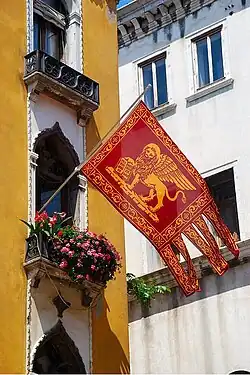 Une réplique moderne du drapeau déployé depuis un balcon à Venise.