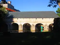 Bâtiment horizontal surplombant l'eau qui passe sous des arches.