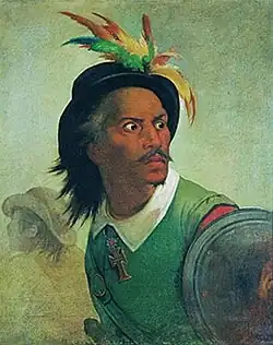 Peinture en couleurs. Portrait en buste d'un homme à la couleur foncée et aux tempes grisonnantes. Il porte un chapeau à plumes colorées, une veste verte et un bouclier en fer. Il est en mouvement, son corps se déplaçant vers la gauche, tandis qu'il a le regard tourné vers la droite.