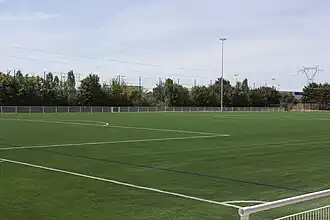 Vue d'un terrain de sport en gazon synthétique.