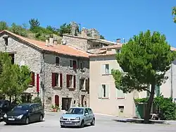 Place bordée de deux maisons en pierres apparentes.
