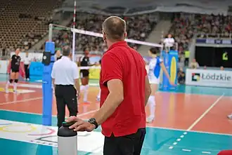 Au volley-ball, l'entraîneur faisant une demande de temps mort.