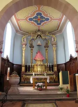 Maître-autel baroque (1751), stalles (XIXe) et fonts baptismaux (XVIIe).