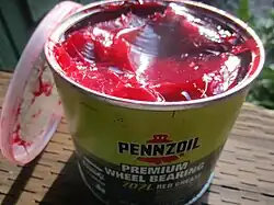 Image d'un pot contenant une graisse rouge et épaisse. Cette graisse est destinée à la mécanique automobile. Cette graisse inclut du savon dans sa composition.