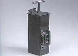 Photo d'une boite rectangulaire d'où dépasse une poignée.