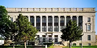 Vue partielle de la façade d'un bâtiment de pierres sur trois étages avec des colonnes sur la façade.