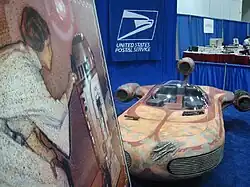 Maquette d'un véhicule orange et rouge.