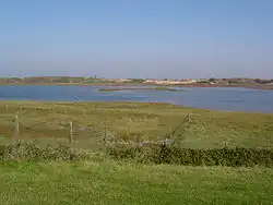 Photo d'une lagune entourée de dunes et de prés salés