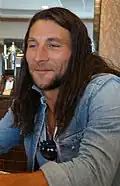 Zach McGowan interprète Roan.