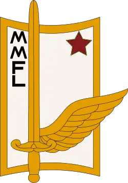 Blason rectangulaire blanc bordé d'or, les bords supérieur et inférieurs convexe, portant légèrement sur la gauche une épée posée poignée en bas sur une aile ouverte à sa droite, toutes deux d'or également ; en haut à gauche, disposées verticalement, les lettres M, M, F, L ; en haut à droite, une étoile rouge.