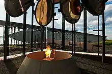 Jeu de miroirs avec au centre une chaise où brûle une flamme éternelle symbolisant le bûcher où sont morts les suppliciés