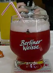 Verre de bière avec une paille.
