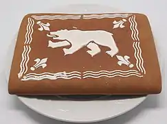 Photographie en couleur d'un gâteau rectangulaire décoré d'un glaçage blanc en forme d'ours.