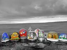 Photographie de neuf boules en plastique avec des formes moches à l’intérieur.