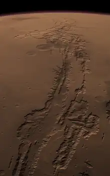 Surface ocre de la planète Mars en simulation vue du ciel, montrant une vallée