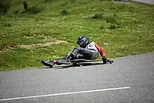 Personne descendant une route sur une planche à roulettes.