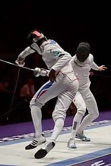 Photographie de deux personnes avec des lames fines et des protections sur le corps.