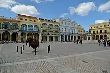 Photographie d’une place avec des immeubles colorés.