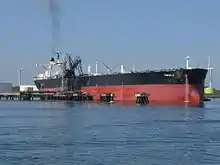 transporteur de brut Omala amarré à Rotterdam, très long navire à coque rouge surmonté de noir.