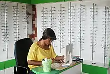 Photographie d'une femme entourée de lunettes.