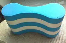 Objet en mousse creusé sur les flancs, vers le centre, un peu comme un os.