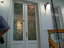 Photographie d’une porte barrée d’une grille ouvragée.