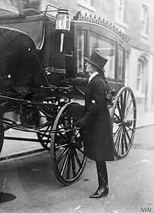 photographie : femme avec chapeau haut de forme devant un corbillard
