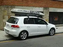 Photographie d’une voiture vue de côté avec un compartiment de stockage sur le toit.