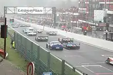 Photographie d'un départ de course automobile, vue de derrière