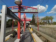 Ciel bleu avec quelques nuages, palmiers, et vue du quai.