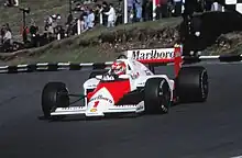 Photo d'une voiture de Formule 1 rouge et blanche sur une piste de circuit