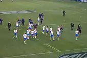 Le match fini, les joueurs italiens fêtent la victoire les bras levés sur le stade (plan large).