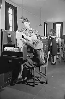 Photo noir/blanc d'une femme avec des meubles à fiches.