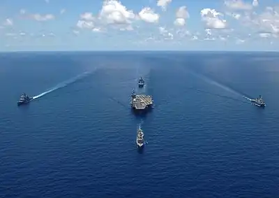 Le George Washington en formation avec 4 navires d'escorte, en haute mer.