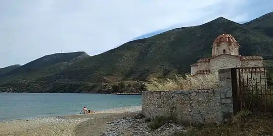 Vue de l'église au bord de la plage au pied du Mont Arabikias .