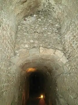 Galerie du vomitoire ouestLa voûte à mi-hauteur est médiévale ; elle sépare la galerie en deux niveaux de caves..