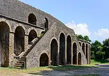 Vue d'un escalier double plaqué contre la façade d'un amphithéâtre.
