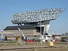 Photographie en couleurs d’un bâtiment dans un port.