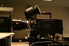 Photographie d'une caméra imposante posée dans un appartement.