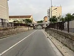 Viaduc de la Ligne de La Plaine à Ermont - Eaubonne et ancienne Usine PSA de Saint-Ouen (au fond à gauche) en juin 2022.