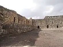 cour nue bordée de deux murailles de pierre