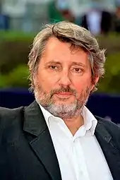 Photographie en couleurs d'un homme en costume.