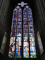 Photo de la baie 51 montrant des vitraux anciens en partie supérieure et plus récents sur le registre inférieur