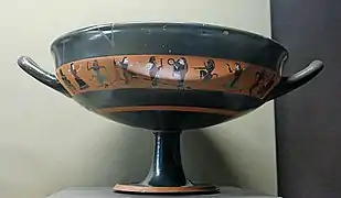 coupe noire, ornée d’une bande de peintures noires sur fond rouge.