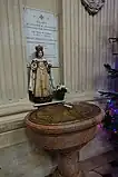 Fonts baptismaux avec une statue de l'Enfant Jésus de Prague.