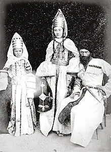 Photographie ethnologique d'un homme et de deux femmes caucasiens en costume traditionnel.