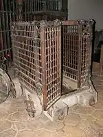 Autre accessoire, une cage en métal sur roues.