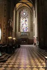 Photographie intérieure d'une église gothique se terminant par une rosace.
