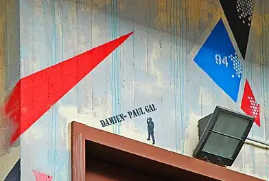 Signature «&nbsp;Damien-Paul Gal&nbsp;» et logo du spray Montana 94 au-dessus d'une issue de secours.